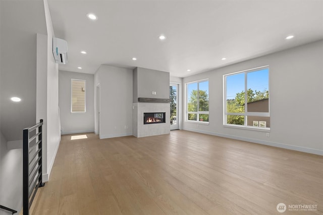 4570 22nd Ave SW, Seattle, WA 98106 - unfurnished living room with baseboards, recessed lighting, light wood-style flooring, a tile fireplace, and a wall mounted AC