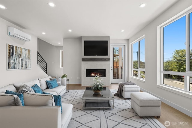 4570 22nd Ave SW, Seattle, WA 98106 - living area featuring light wood-style floors, recessed lighting, a wall mounted air conditioner, a tile fireplace, and baseboards