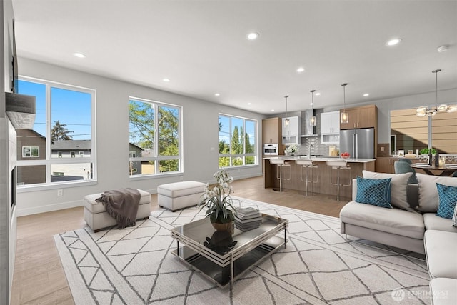 4570 22nd Ave SW, Seattle, WA 98106 - living area featuring light wood-style floors, recessed lighting, a chandelier, and baseboards