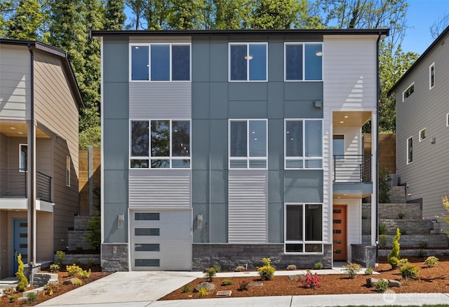 4570 22nd Ave SW, Seattle, WA 98106 - contemporary house with a balcony, stone siding, and driveway