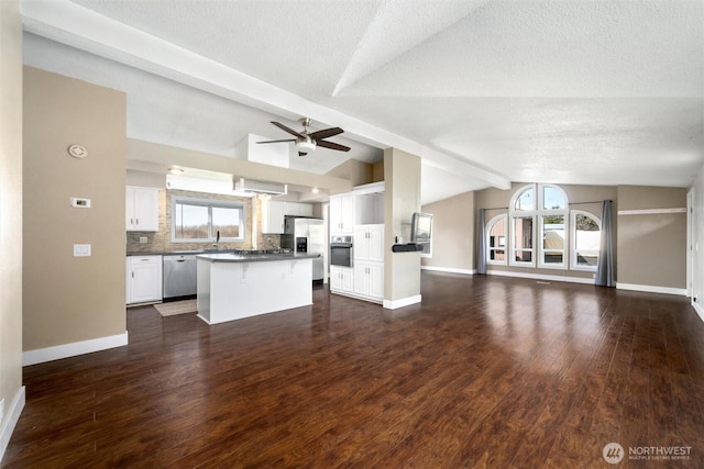 4241 Rural Ave, Bellingham, WA 98226 - unfurnished living room featuring healthy amount of natural light, dark wood-style floors, baseboards, and a textured ceiling