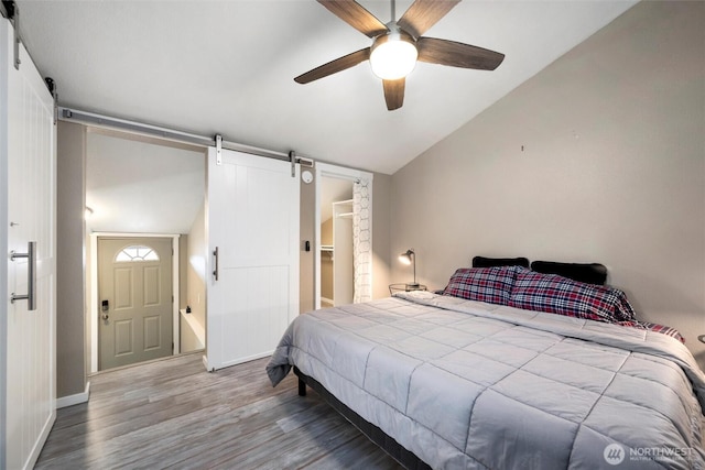 4241 Rural Ave, Bellingham, WA 98226 - bedroom with a barn door, vaulted ceiling, wood finished floors, baseboards, and a ceiling fan