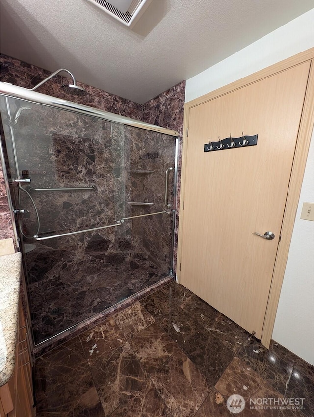 6960 California Ave SW Unit A104, Seattle, WA 98136 - bathroom featuring a marble finish shower, marble finish floors, and vanity