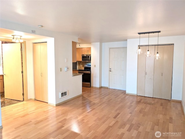 6960 California Ave SW Unit A104, Seattle, WA 98136 - unfurnished living room featuring light wood-style flooring and baseboards