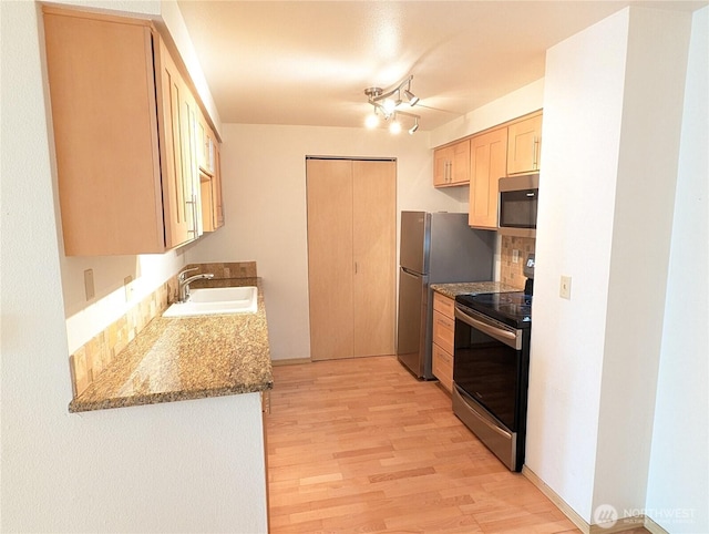 6960 California Ave SW Unit A104, Seattle, WA 98136 - kitchen with stainless steel appliances, light wood-style floors, light brown cabinetry, and stone countertops