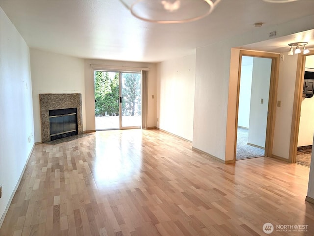 6960 California Ave SW Unit A104, Seattle, WA 98136 - unfurnished living room featuring light wood-style flooring and a high end fireplace