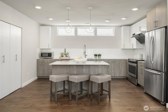 13329 1st Ave NE, Seattle, WA 98125 - kitchen featuring stainless steel appliances, a kitchen breakfast bar, a kitchen island, light countertops, and backsplash