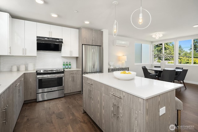 13329 1st Ave NE, Seattle, WA 98125 - kitchen with stainless steel appliances, range hood, a wall unit AC, a kitchen island, and light countertops