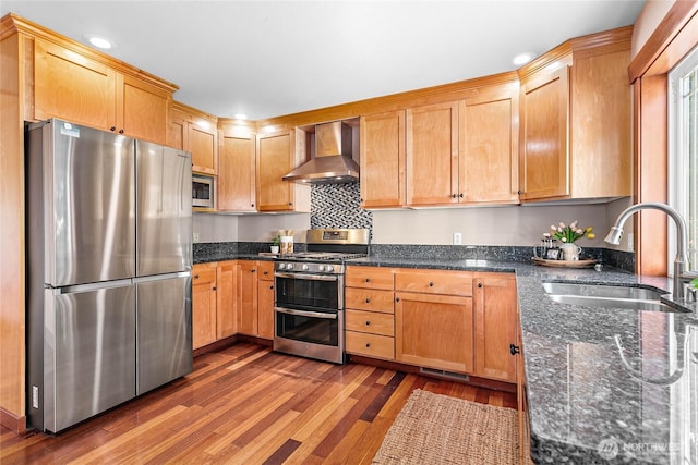 3276 Spyglass Dr, Bellingham, WA 98226 - kitchen with stainless steel appliances, wall chimney range hood, a sink, wood finished floors, and dark stone counters