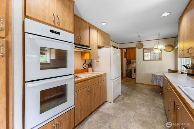 7425 S Alaska St, Tacoma, WA 98408 - kitchen with white appliances, under cabinet range hood, light countertops, washer / clothes dryer, and brown cabinetry