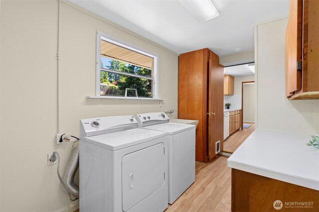 20608 1st Ave S, Des Moines, WA 98198 - laundry room featuring cabinet space, light wood-style floors, and independent washer and dryer