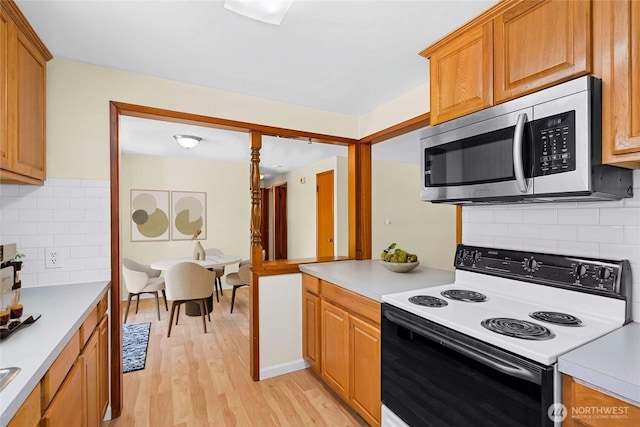 20608 1st Ave S, Des Moines, WA 98198 - kitchen featuring stainless steel microwave, electric range oven, light countertops, and light wood-style floors