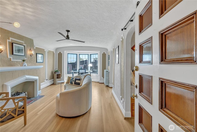 1101 17th Ave Unit 403, Seattle, WA 98122 - living area featuring light wood-style flooring, ceiling fan, baseboards, a textured ceiling, and vaulted ceiling