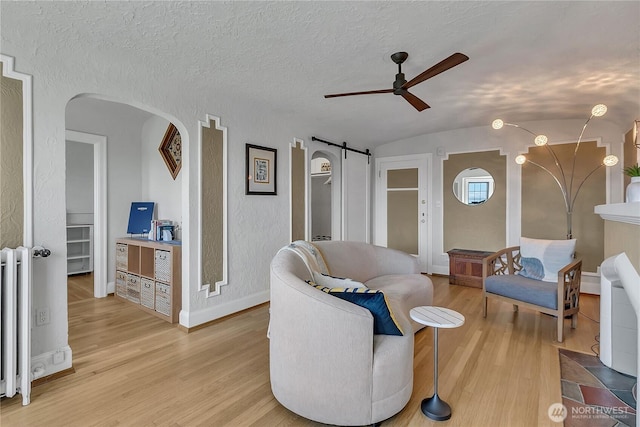 1101 17th Ave Unit 403, Seattle, WA 98122 - living room with ceiling fan, light wood-type flooring, arched walkways, lofted ceiling, and baseboards