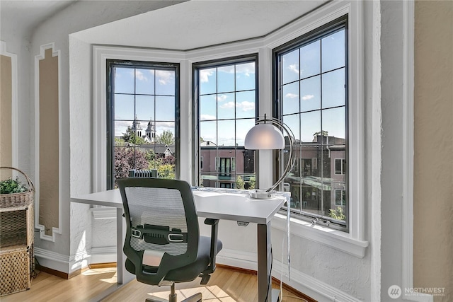1101 17th Ave Unit 403, Seattle, WA 98122 - home office featuring plenty of natural light, baseboards, wood finished floors, and a textured wall