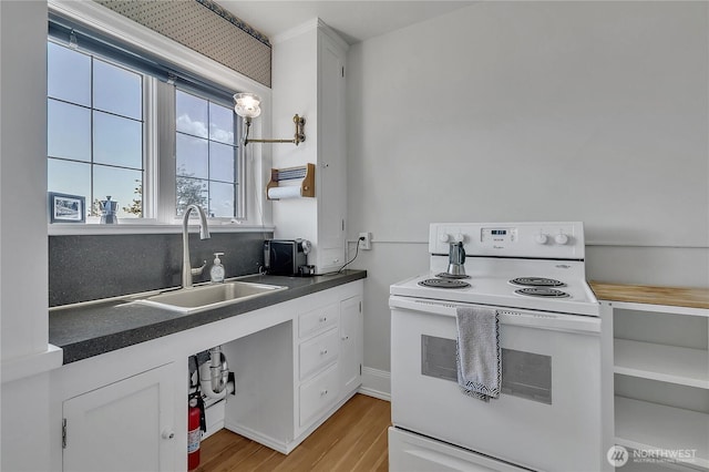 1101 17th Ave Unit 403, Seattle, WA 98122 - kitchen with electric range, a sink, dark countertops, light wood-style flooring, and white cabinetry
