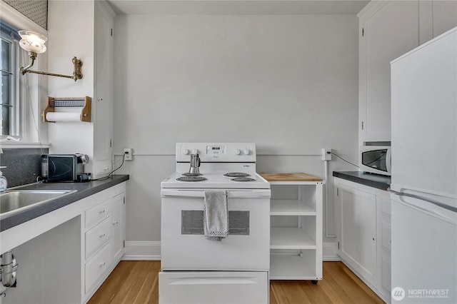 1101 17th Ave Unit 403, Seattle, WA 98122 - kitchen with white appliances, light wood-type flooring, dark countertops, and white cabinetry