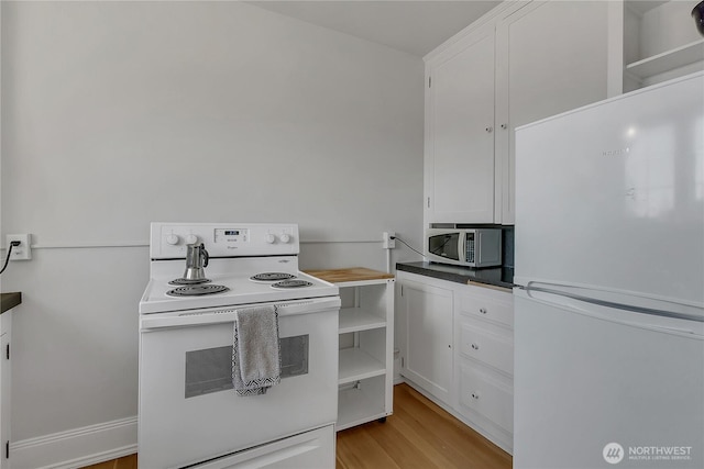 1101 17th Ave Unit 403, Seattle, WA 98122 - kitchen featuring white appliances, white cabinets, light wood-type flooring, and dark countertops