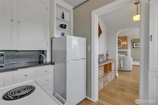 1101 17th Ave Unit 403, Seattle, WA 98122 - kitchen with freestanding refrigerator, arched walkways, light wood-type flooring, white cabinetry, and dark countertops