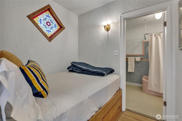 1101 17th Ave Unit 403, Seattle, WA 98122 - bedroom featuring wood finished floors and a textured wall