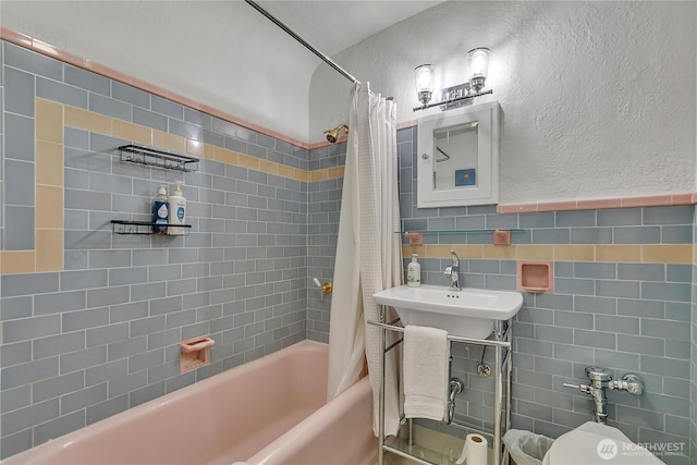 1101 17th Ave Unit 403, Seattle, WA 98122 - full bathroom featuring tile walls, shower / tub combo with curtain, a textured wall, and a sink