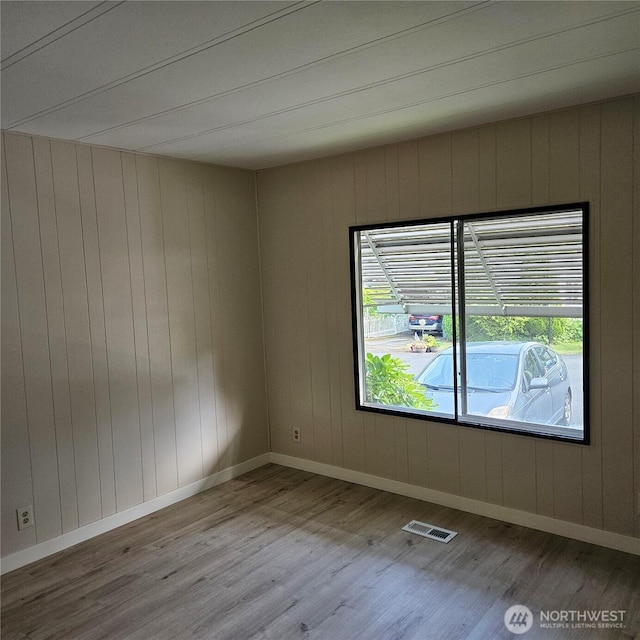 7031 NE 175th St Unit 20, Kenmore, WA 98028 - spare room with wood finished floors, baseboards, and wooden walls