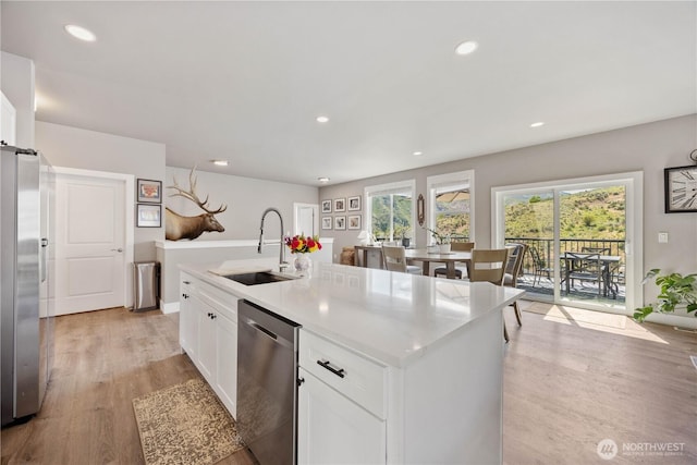 9968 Griffith Pl, Entiat, WA 98822 - kitchen with stainless steel appliances, a sink, white cabinets, light wood-type flooring, and an island with sink