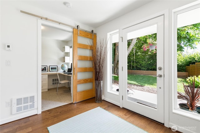 2736 SW Holden St, Seattle, WA 98126 - entryway featuring healthy amount of natural light, a desk, a barn door, and wood finished floors