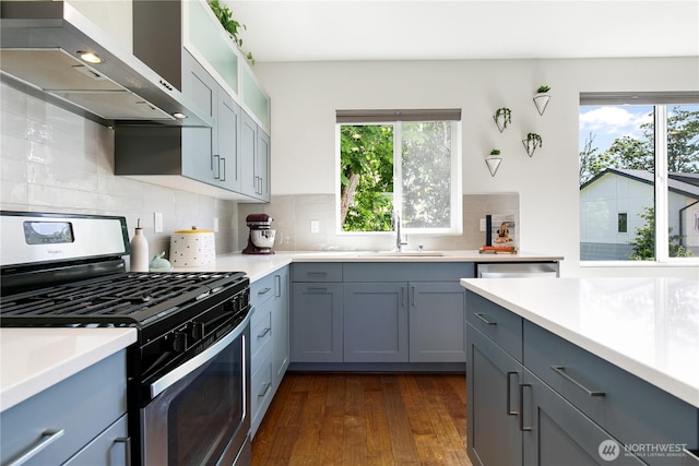 2736 SW Holden St, Seattle, WA 98126 - kitchen with stainless steel range with gas cooktop, wall chimney range hood, healthy amount of natural light, and gray cabinetry
