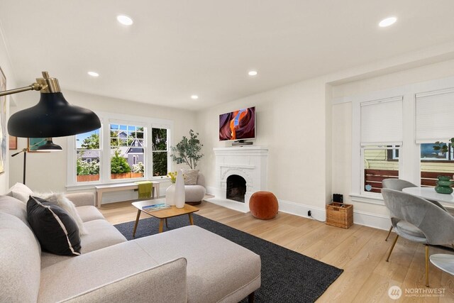 4607 1st Ave NE, Seattle, WA 98105 - living room with wood finished floors, a fireplace with raised hearth, and recessed lighting