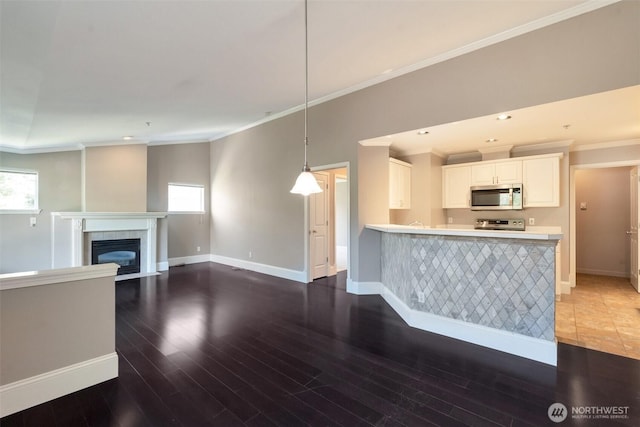 2198 Palisade Blvd Unit C2, Dupont, WA 98372 - unfurnished living room featuring crown molding, baseboards, wood finished floors, a fireplace with flush hearth, and recessed lighting