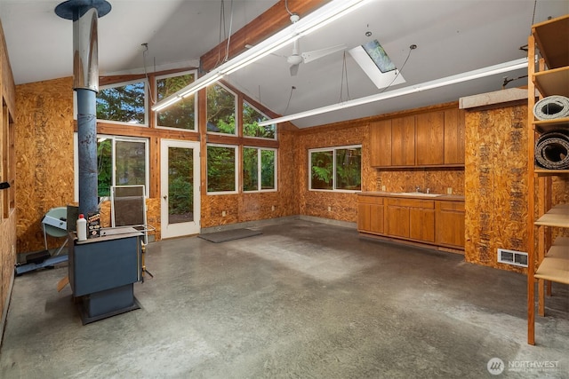 2 Edgewater Dr, Camano Island, WA 98282 - unfurnished living room with concrete floors, a wood stove, a skylight, and high vaulted ceiling