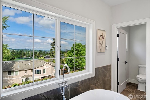 12811 SE 44th Pl, Bellevue, WA 98006 - bathroom featuring a freestanding tub, toilet, and baseboards