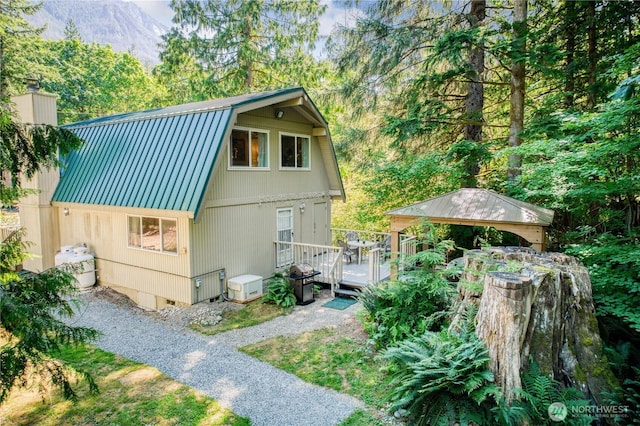 64455 NE 180th St, Baring, WA 98224 - view of side of home with a gambrel roof, metal roof, a gazebo, and a wooden deck