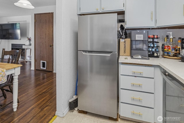 2209 Mciver Ct SW, Tumwater, WA 98512 - kitchen with freestanding refrigerator, light countertops, beverage cooler, wood finished floors, and white cabinetry