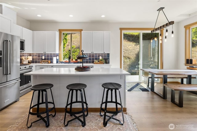 720 Stone Ridge Dr, Cle Elum, WA 98922 - kitchen with stainless steel appliances, a sink, a kitchen bar, light countertops, and white cabinetry