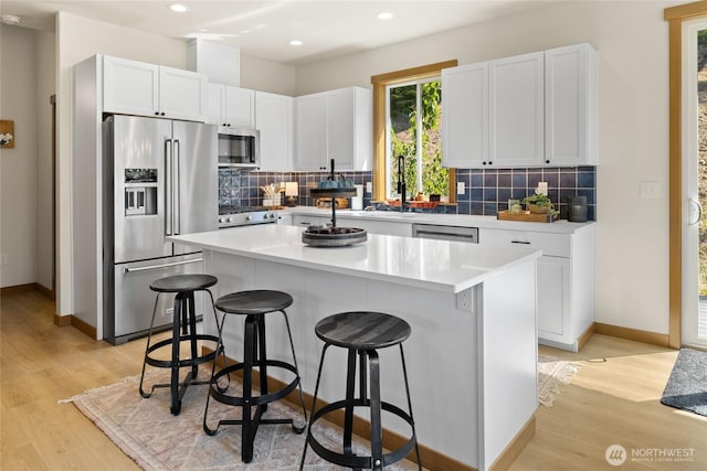 720 Stone Ridge Dr, Cle Elum, WA 98922 - kitchen featuring stainless steel appliances, a breakfast bar, a sink, light wood-style floors, and recessed lighting