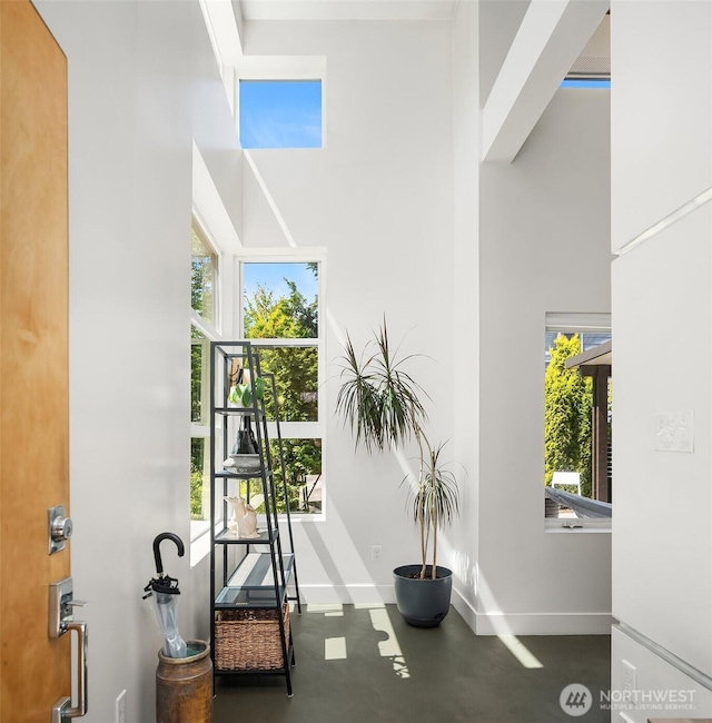 8622 NE 177th Pl, Bothell, WA 98011 - hallway featuring baseboards, a high ceiling, and concrete floors