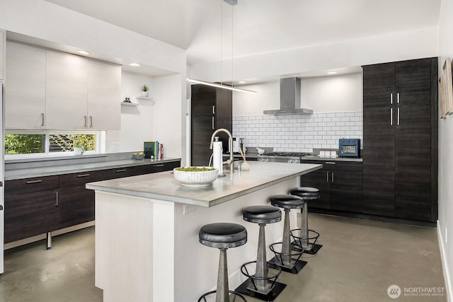 8622 NE 177th Pl, Bothell, WA 98011 - kitchen featuring concrete floors, wall chimney range hood, decorative backsplash, a kitchen bar, and recessed lighting