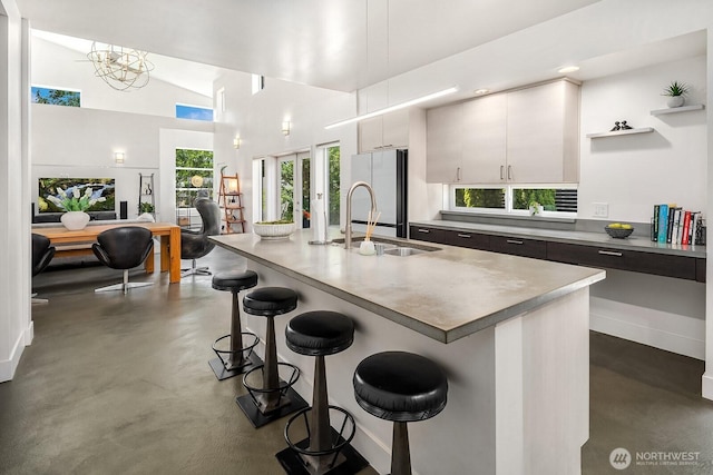 8622 NE 177th Pl, Bothell, WA 98011 - kitchen with finished concrete floors, freestanding refrigerator, a sink, a breakfast bar, and a center island with sink