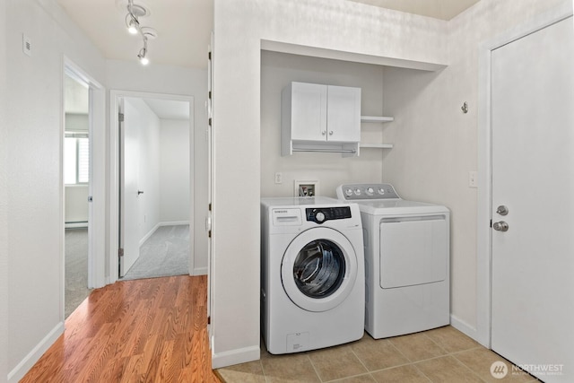 18200 73rd Ave NE Unit B205, Kenmore, WA 98028 - laundry area with washing machine and clothes dryer, a baseboard heating unit, baseboards, and light wood-style floors