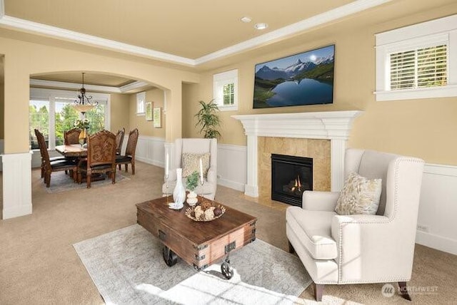 28816 118th Ave SE, Auburn, WA 98092 - carpeted living room featuring crown molding, a raised ceiling, arched walkways, wainscoting, and a high end fireplace