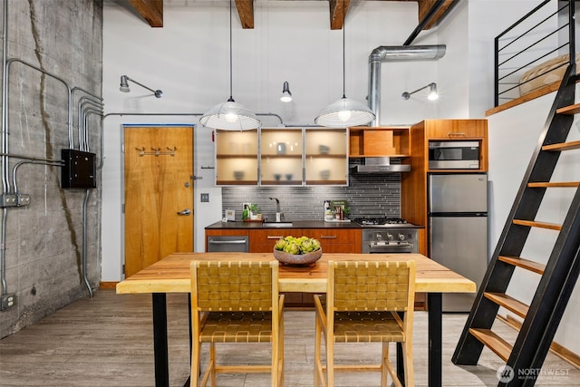 1505 11th Ave Unit 310, Seattle, WA 98122 - kitchen with stainless steel appliances, decorative backsplash, wood finished floors, dark countertops, and a sink