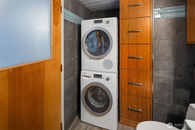 1505 11th Ave Unit 310, Seattle, WA 98122 - laundry room featuring stacked washing machine and dryer, tile walls, and wood finished floors