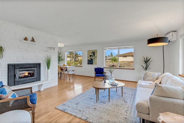5501 N 14th St, Tacoma, WA 98406 - living room with a wall mounted air conditioner, wood finished floors, and a stone fireplace