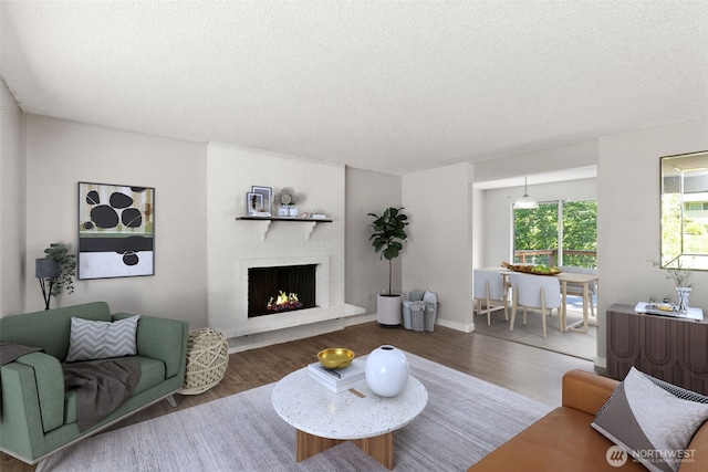 8539 University Point Cir NE, Bremerton, WA 98311 - living room with a textured ceiling, wood finished floors, and a brick fireplace