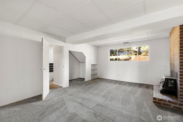 8539 University Point Cir NE, Bremerton, WA 98311 - unfurnished living room featuring a wood stove, carpet floors, and a drop ceiling