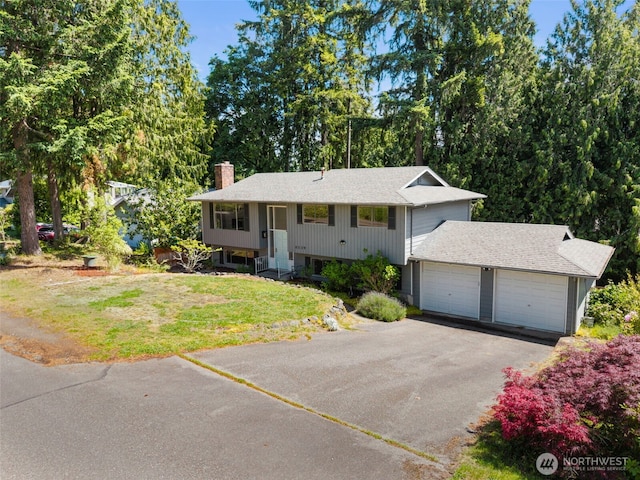 8539 University Point Cir NE, Bremerton, WA 98311 - split foyer home featuring a chimney, a front lawn, asphalt driveway, and a garage