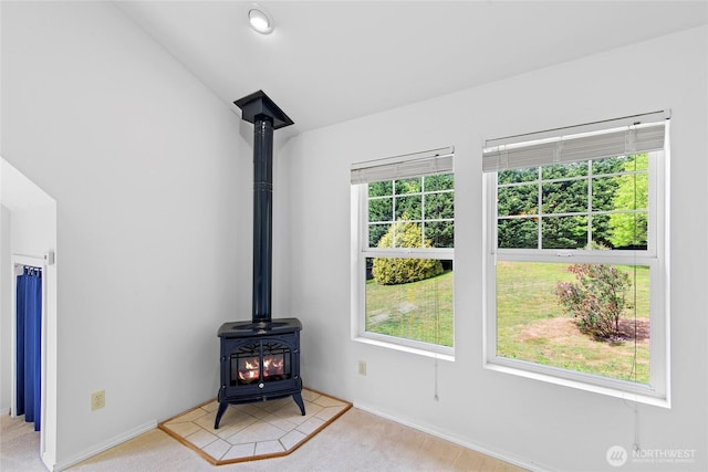 8000 NE W Port Madison Rd, Bainbridge Island, WA 98110 - unfurnished living room featuring a wood stove, carpet, baseboards, and lofted ceiling
