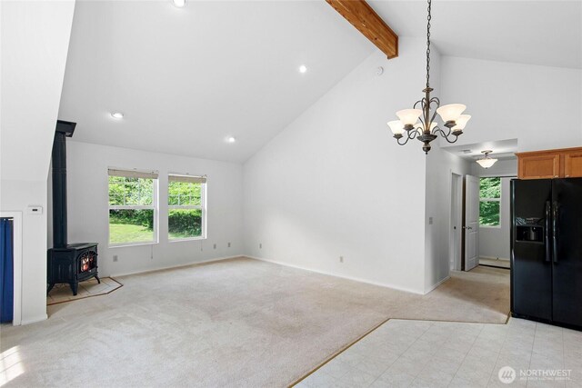 8000 NE W Port Madison Rd, Bainbridge Island, WA 98110 - unfurnished living room with light colored carpet, high vaulted ceiling, beamed ceiling, a wood stove, and a chandelier